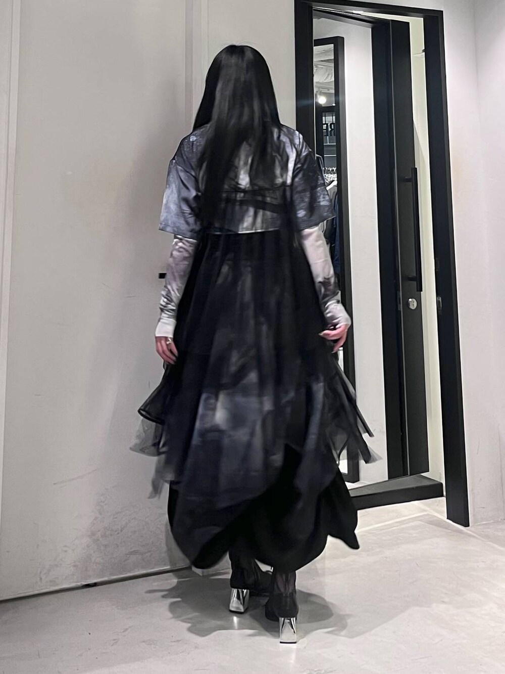 ブラック系のサンダル、ブラック系のスカート、ホワイト系のTシャツ/カットソーを着用したレディースの春コーディネートの4枚目の写真