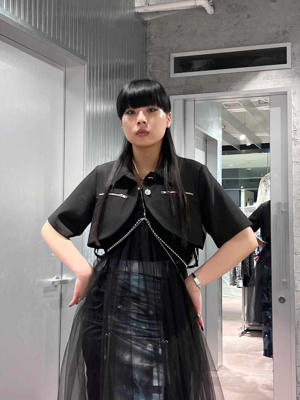 ブラック系のスカート、ブラック系のブーツ、ブラック系のブルゾンを着用したレディースの夏コーディネートの4枚目の写真