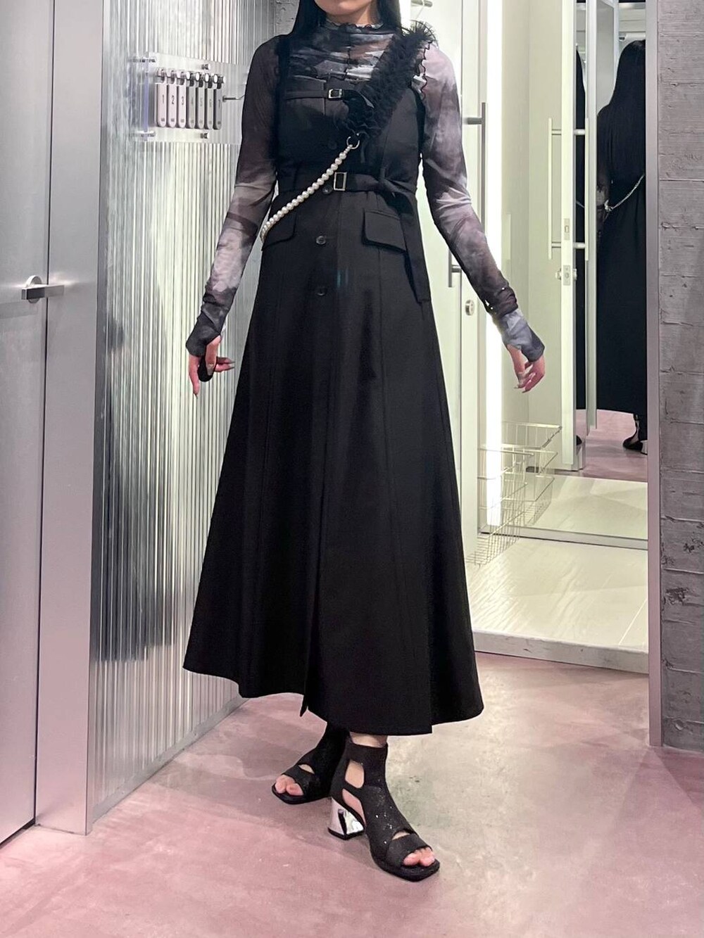 ブラック系のサンダル、ブラック系のジャンパースカート、ブラック系のTシャツ/カットソーを着用したレディースの夏コーディネートの3枚目の写真