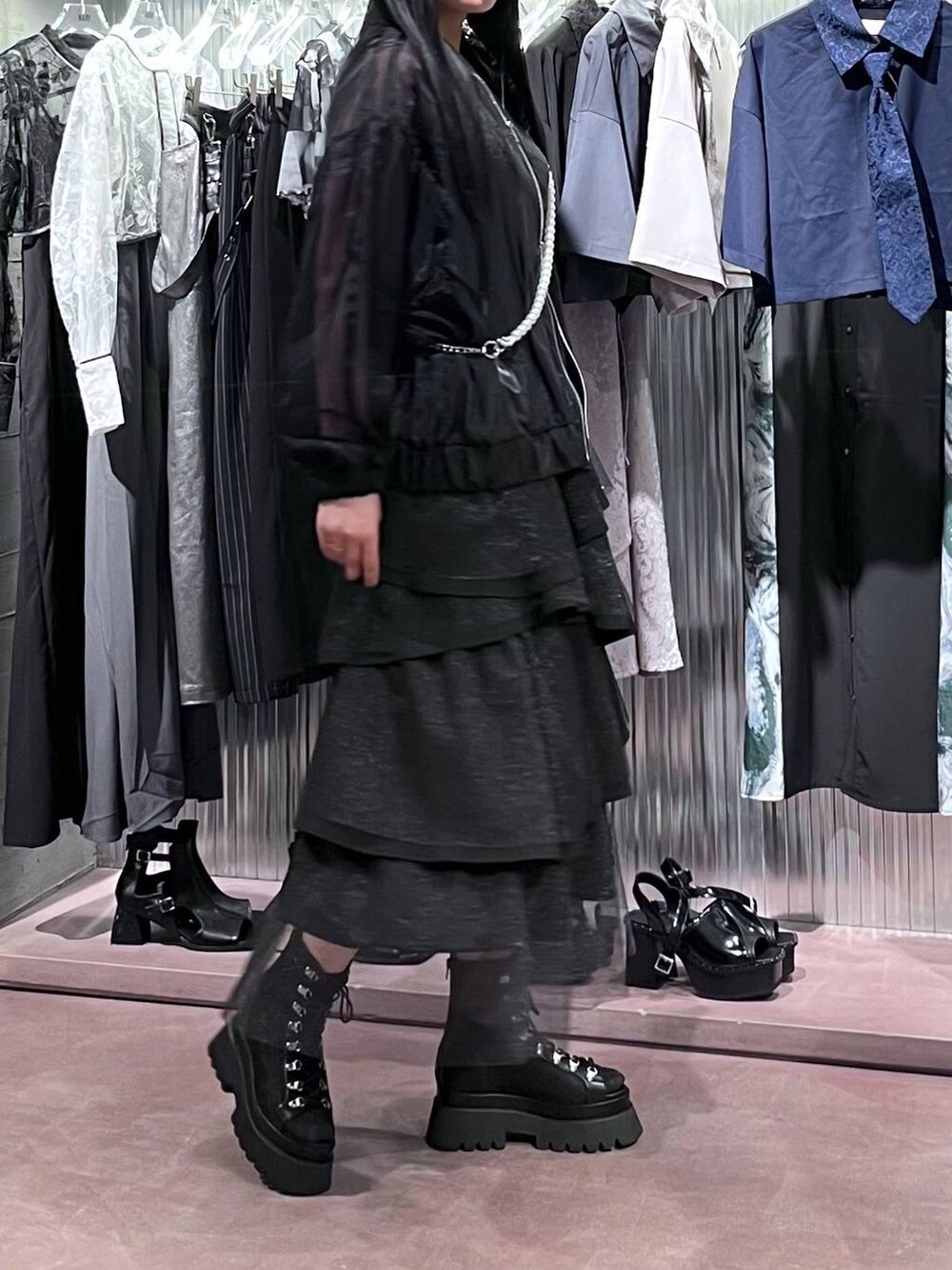 ブラック系のサンダル、ブラック系のスカート、ブラック系のブルゾンを着用したレディースの春コーディネートの3枚目の写真