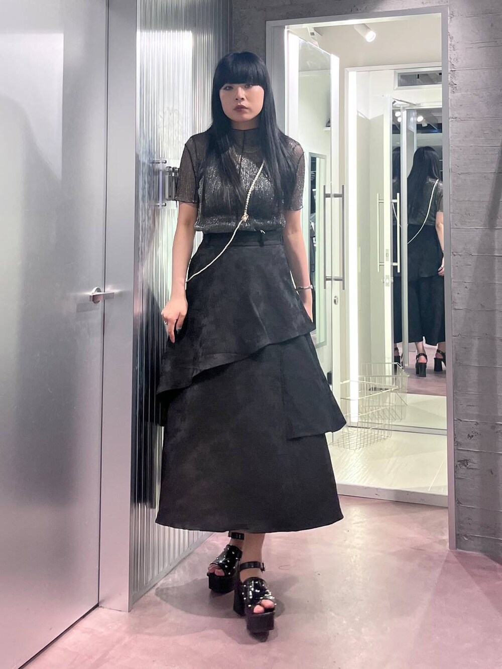 ブラック系のサンダル、ブラック系のスカート、ブラック系のTシャツ/カットソーを着用したレディースの春コーディネートの3枚目の写真