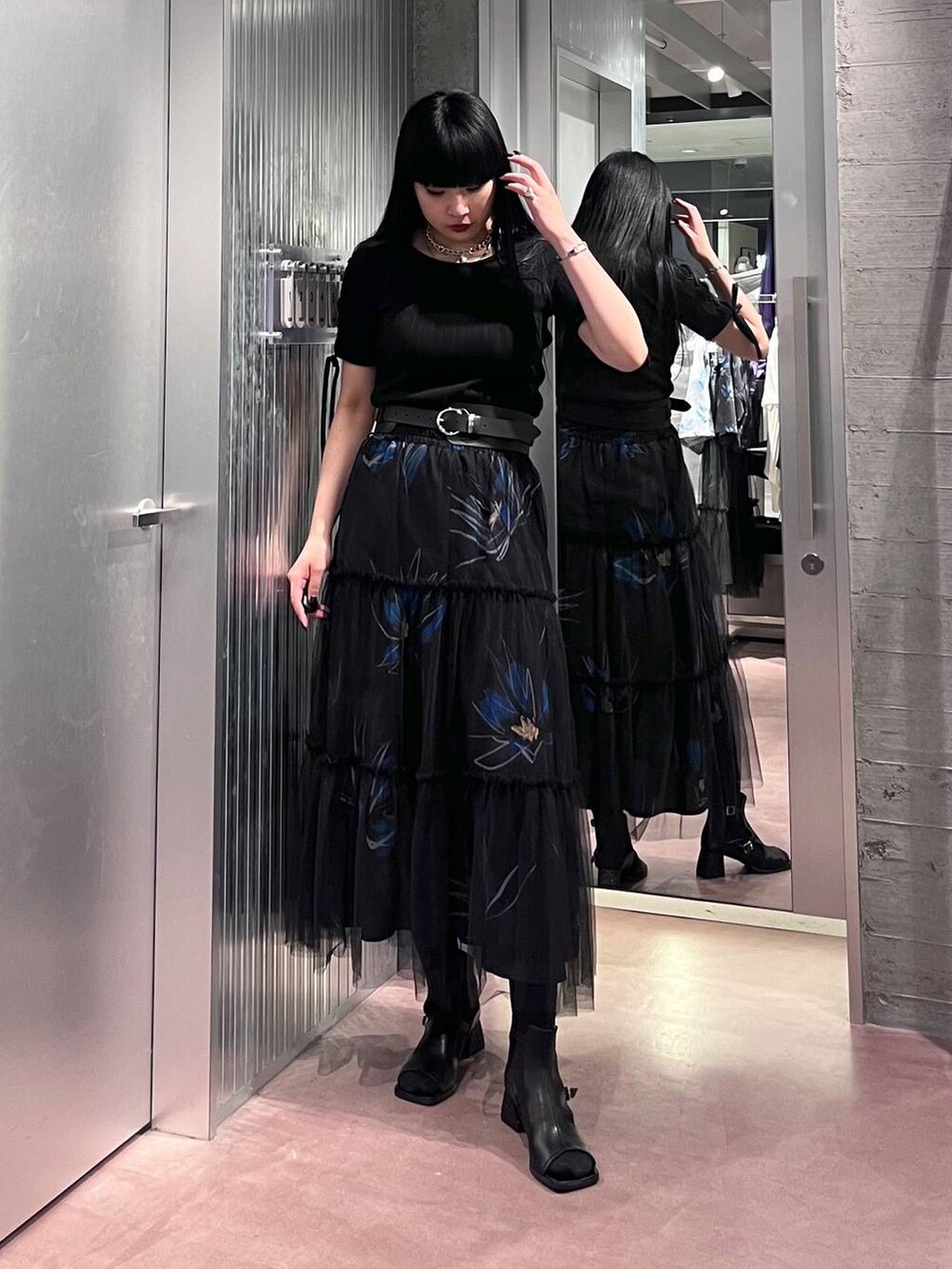 ブラック系のTシャツ/カットソー、ブラック系のスカート、ブラック系のサンダルを着用したレディースの春コーディネートの6枚目の写真