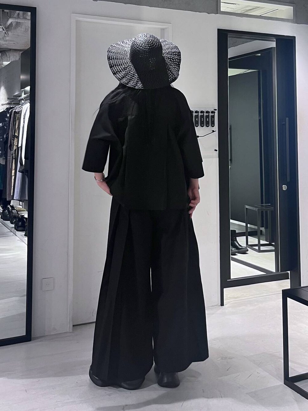 ブラック系のサンダル、ブラック系のその他パンツ、ブラック系のシャツ/ブラウスを着用したレディースの春コーディネートの5枚目の写真