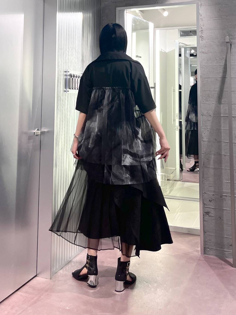 ブラック系のタンクトップ、ブラック系のスカート、ブラック系のサンダルを着用したレディースの夏コーディネートの6枚目の写真