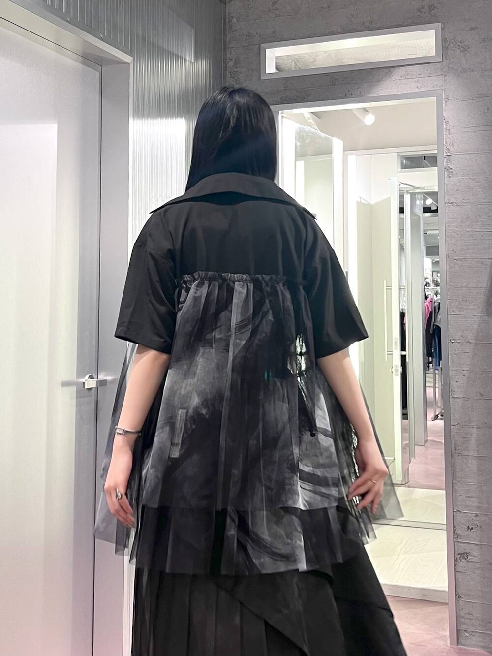 ブラック系のタンクトップ、ブラック系のスカート、ブラック系のサンダルを着用したレディースの夏コーディネートの8枚目の写真