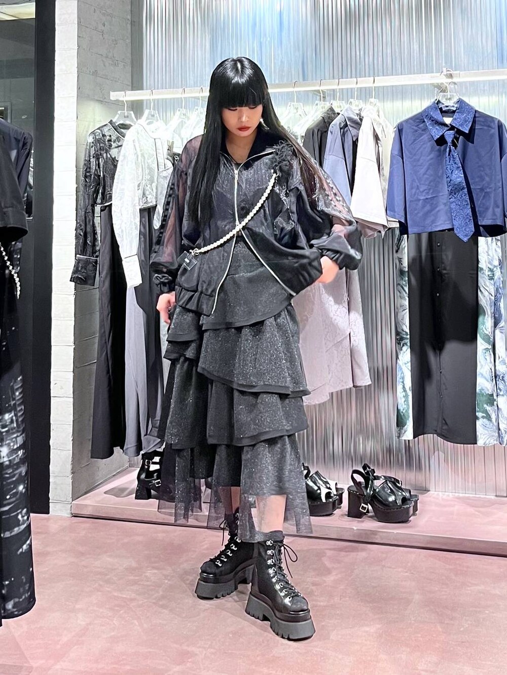 ブラック系のサンダル、ブラック系のスカート、ブラック系のブルゾンを着用したレディースの春コーディネートの2枚目の写真