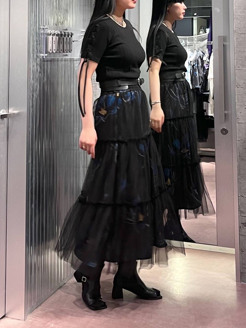 ブラック系のTシャツ/カットソー、ブラック系のスカート、ブラック系のサンダルを着用したレディースの春コーディネートの4枚目の写真