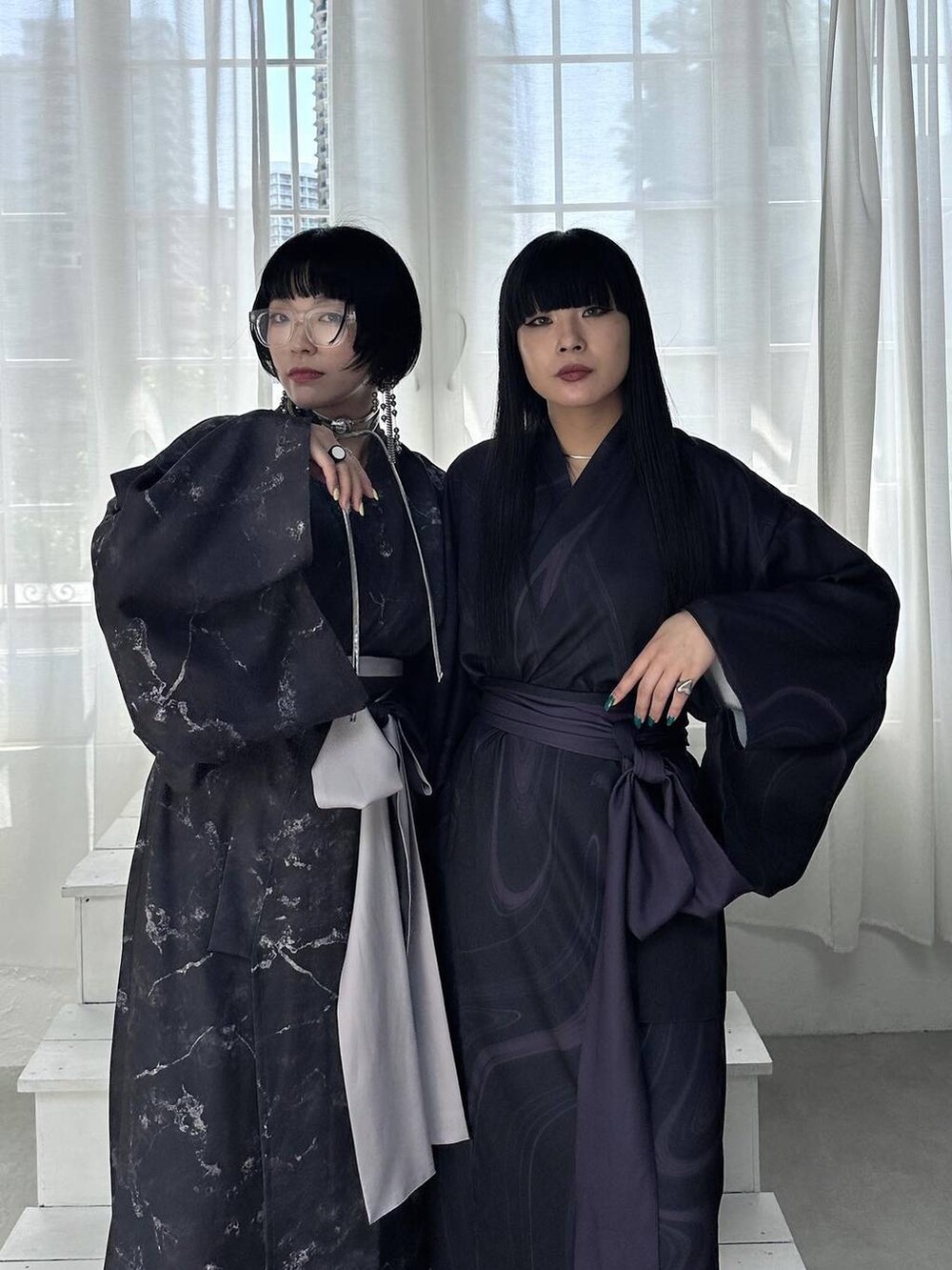 シルバー系のサンダル、ブラック系のブーツ、シルバー系のチョーカーを着用したレディースの春コーディネートの2枚目の写真