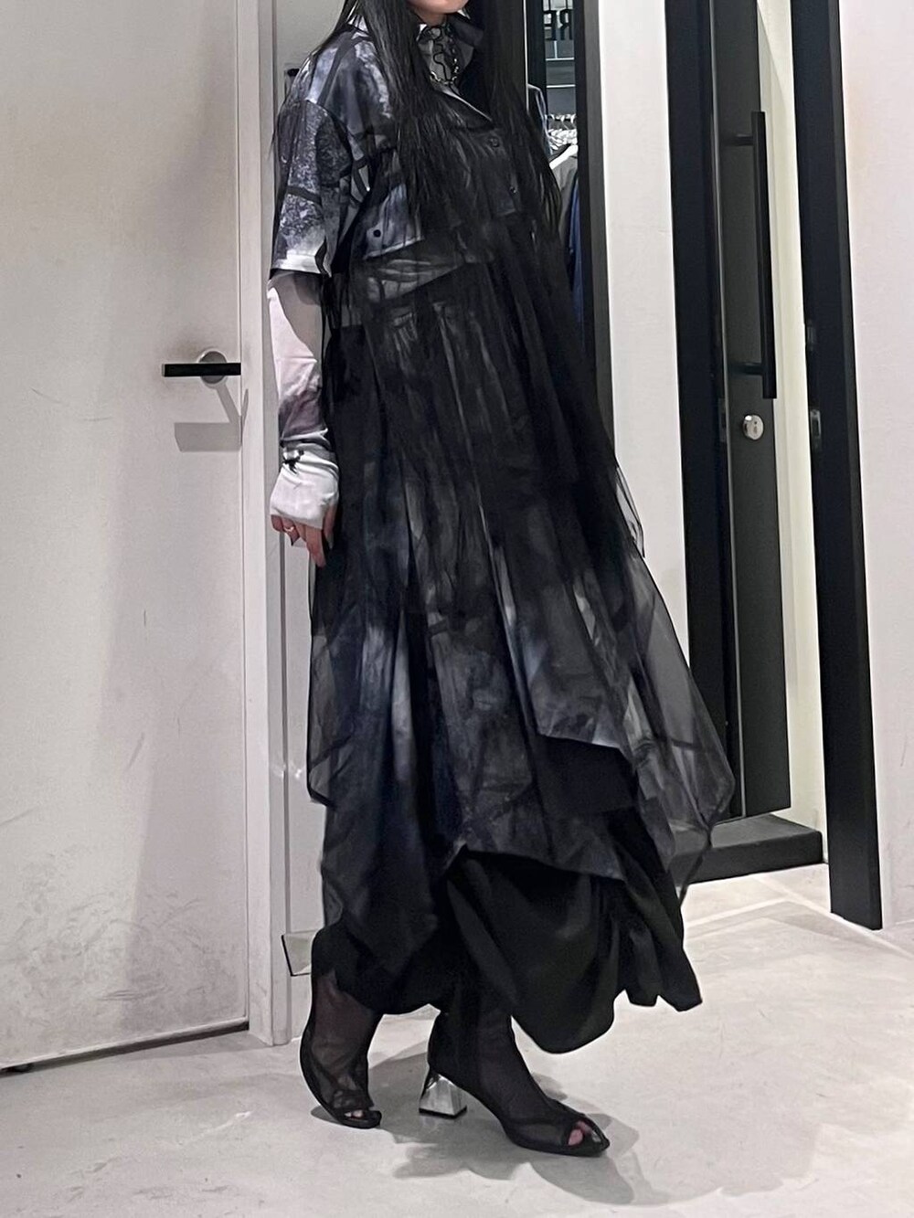 ブラック系のサンダル、ブラック系のスカート、ホワイト系のTシャツ/カットソーを着用したレディースの春コーディネートの3枚目の写真