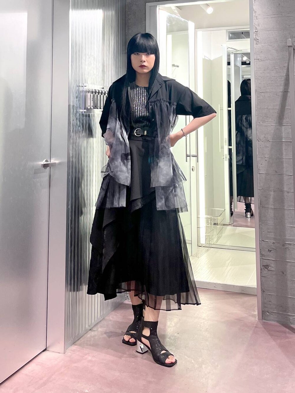 ブラック系のタンクトップ、ブラック系のスカート、ブラック系のサンダルを着用したレディースの夏コーディネートの7枚目の写真