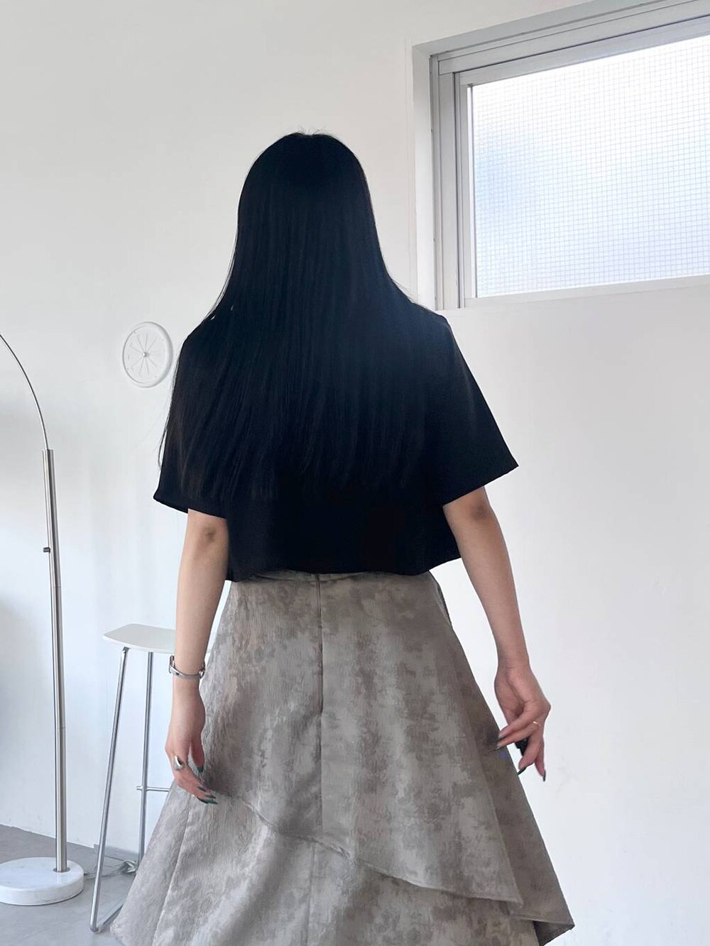 ブラック系のサンダル、グレー系のスカート、ブラック系のTシャツ/カットソーを着用したレディースの春コーディネートの5枚目の写真