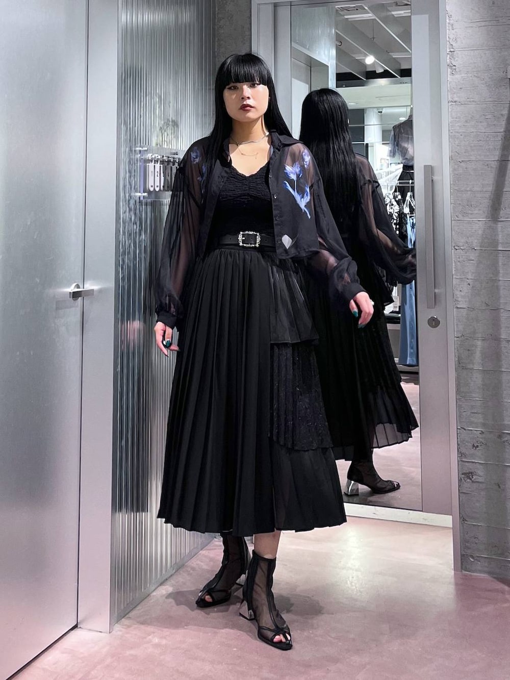 ブラック系のサンダル、ブルー系のシャツ/ブラウス、ブラック系のスカートを着用したレディースの春コーディネートの2枚目の写真