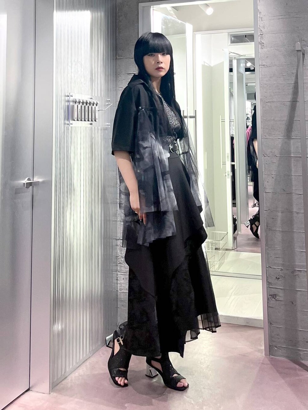 ブラック系のタンクトップ、ブラック系のスカート、ブラック系のサンダルを着用したレディースの夏コーディネートの3枚目の写真