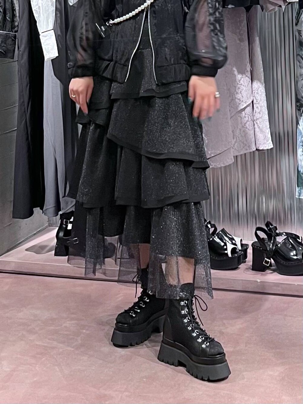 ブラック系のサンダル、ブラック系のスカート、ブラック系のブルゾンを着用したレディースの春コーディネートの7枚目の写真