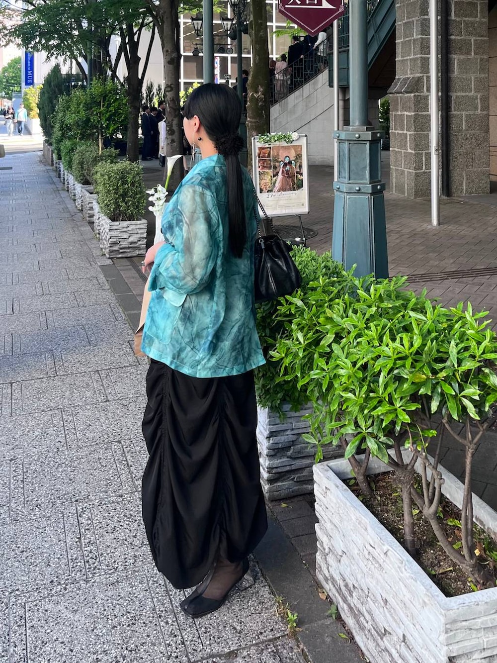 ブラック系のタンクトップ、ブラック系のスカート、グリーン系のテーラードジャケットを着用したレディースの春コーディネートの2枚目の写真