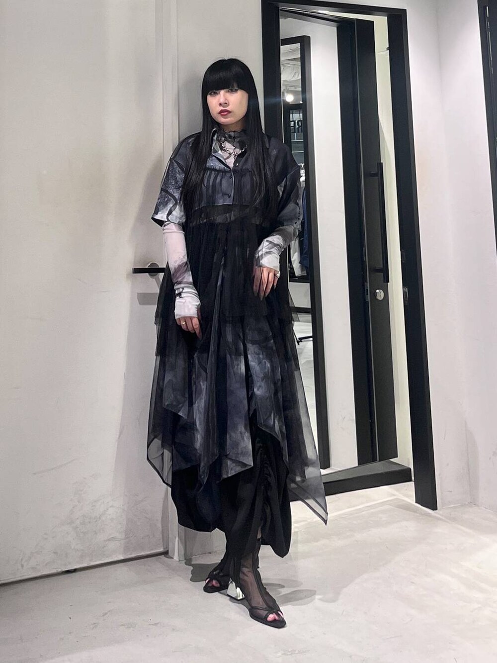 ブラック系のサンダル、ブラック系のスカート、ホワイト系のTシャツ/カットソーを着用したレディースの春コーディネートの2枚目の写真