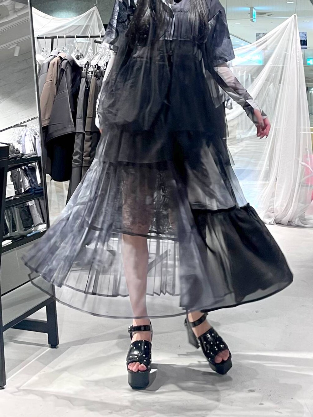 ブラック系のサンダル、ブラック系のスカート、ブラック系のシャツ/ブラウスを着用したレディースの春コーディネートの3枚目の写真