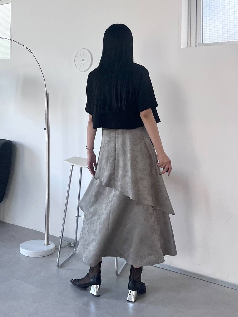 ブラック系のサンダル、グレー系のスカート、ブラック系のTシャツ/カットソーを着用したレディースの春コーディネートの7枚目の写真