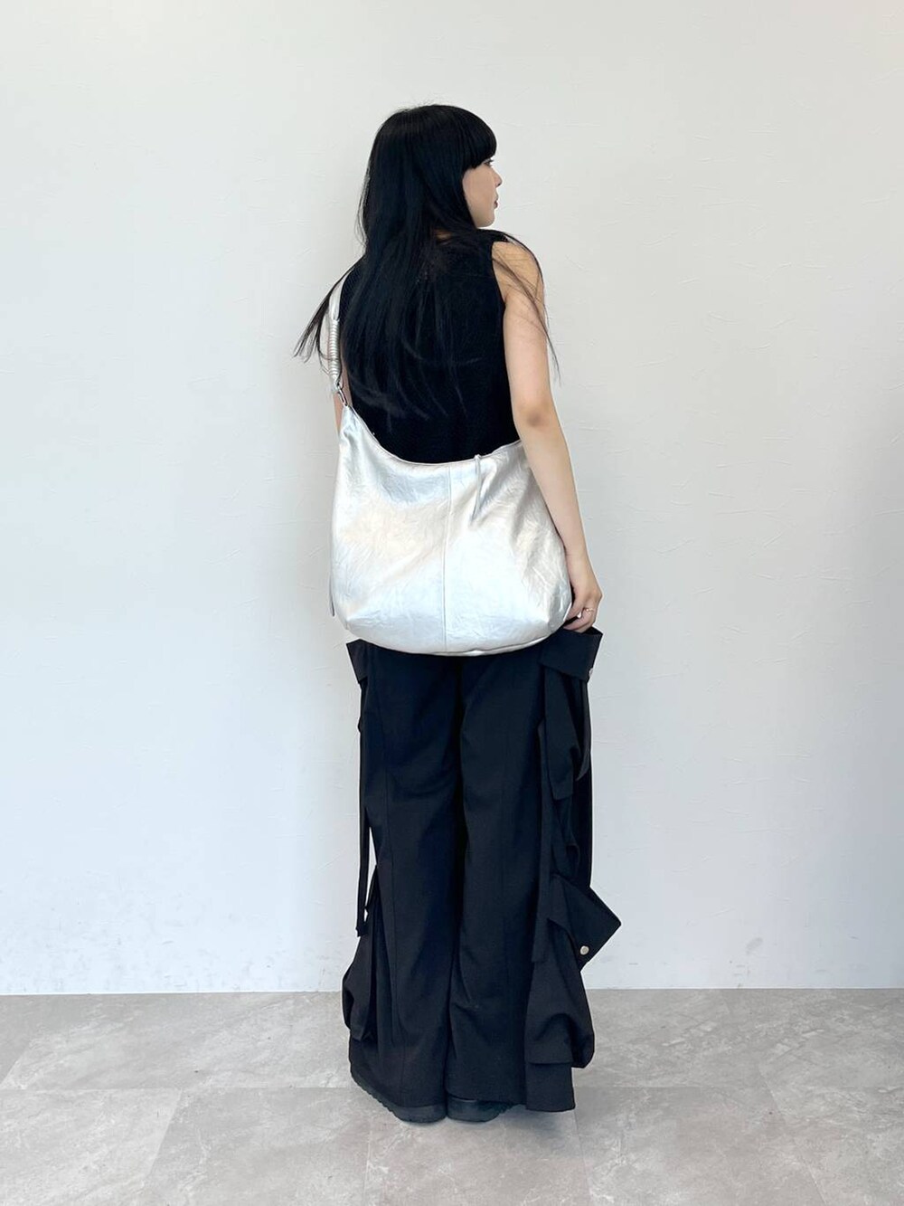 ブラック系のサンダル、シルバー系のショルダーバッグ、ブラック系のスラックスを着用したレディースの夏コーディネートの3枚目の写真