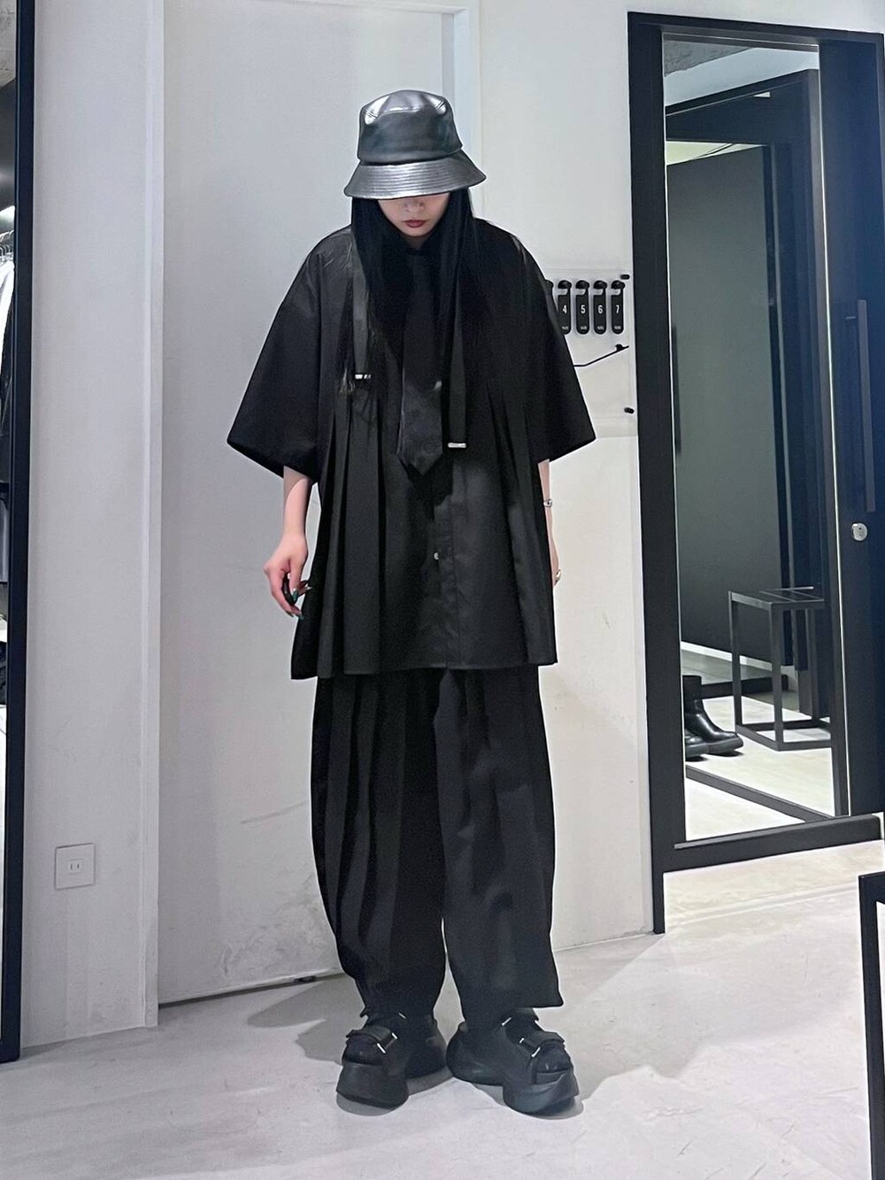 ブラック系のサンダル、ブラック系のネクタイ、ブラック系のその他パンツを着用したレディースの春コーディネートの2枚目の写真