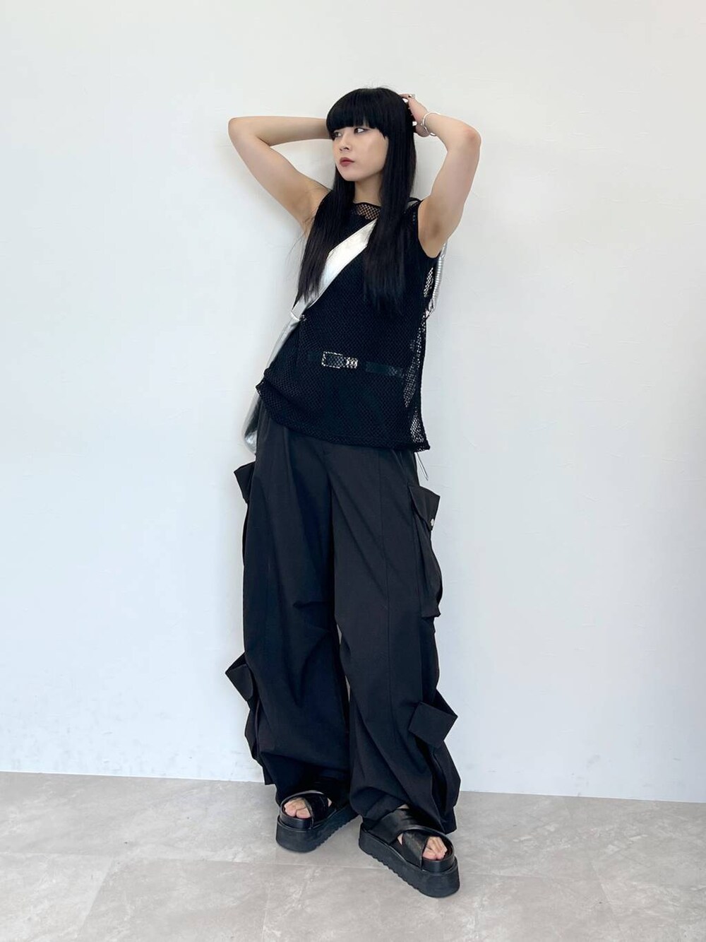 ブラック系のサンダル、シルバー系のショルダーバッグ、ブラック系のスラックスを着用したレディースの夏コーディネートの4枚目の写真