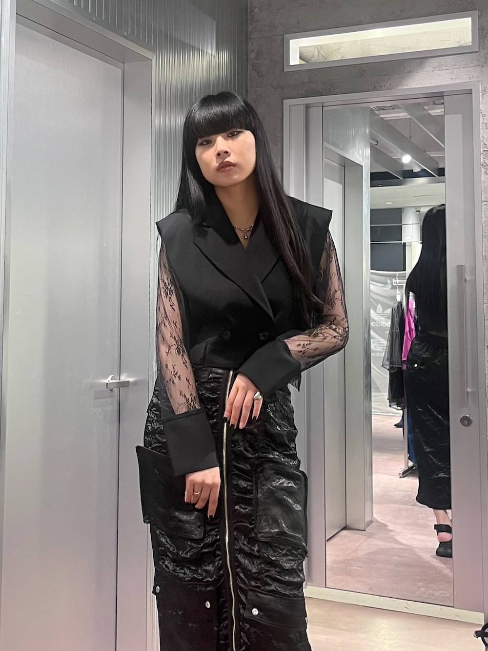 ブラック系のサンダル、ブラック系のテーラードジャケット、ブラック系のスカートを着用したレディースの夏コーディネートの5枚目の写真