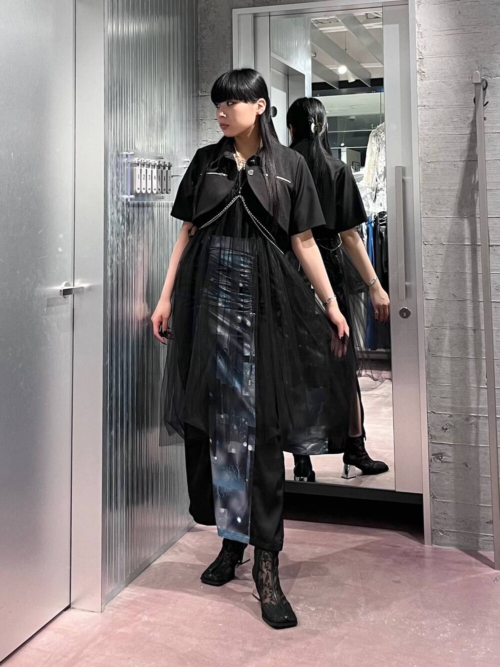 ブラック系のスカート、ブラック系のブーツ、ブラック系のブルゾンを着用したレディースの夏コーディネートの2枚目の写真