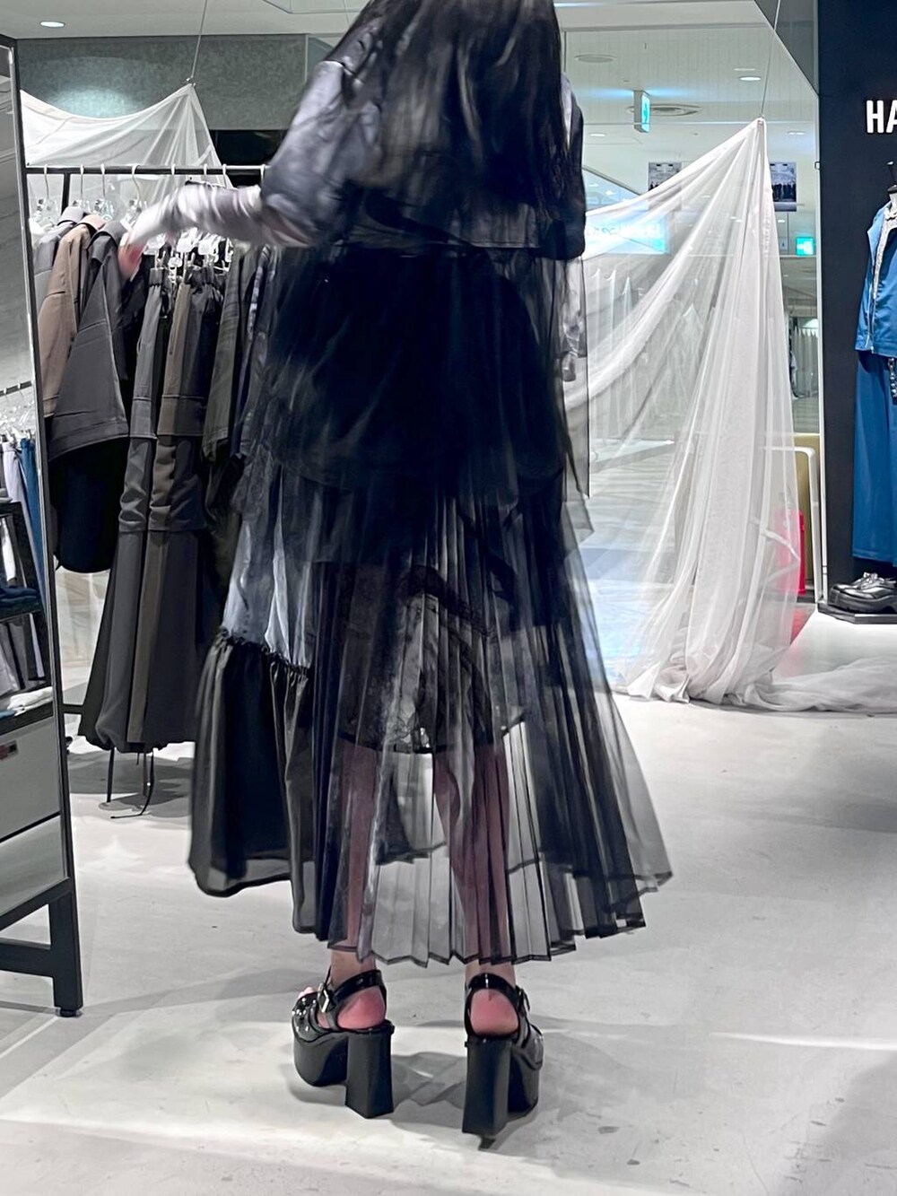 ブラック系のサンダル、ブラック系のスカート、ブラック系のシャツ/ブラウスを着用したレディースの春コーディネートの5枚目の写真