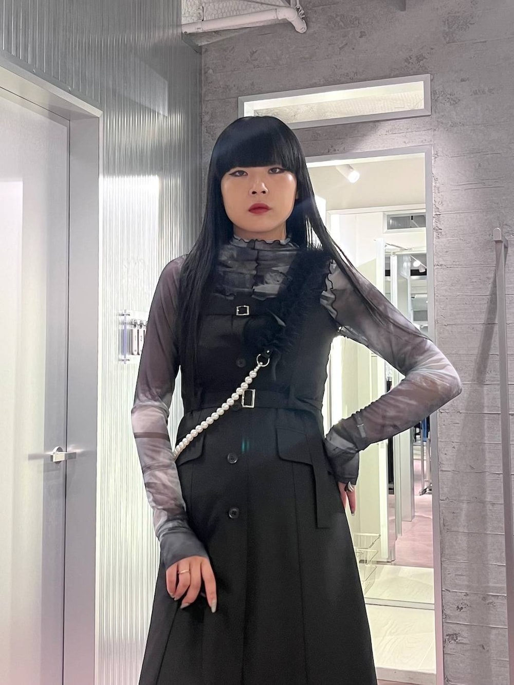 ブラック系のサンダル、ブラック系のジャンパースカート、ブラック系のTシャツ/カットソーを着用したレディースの夏コーディネートの6枚目の写真