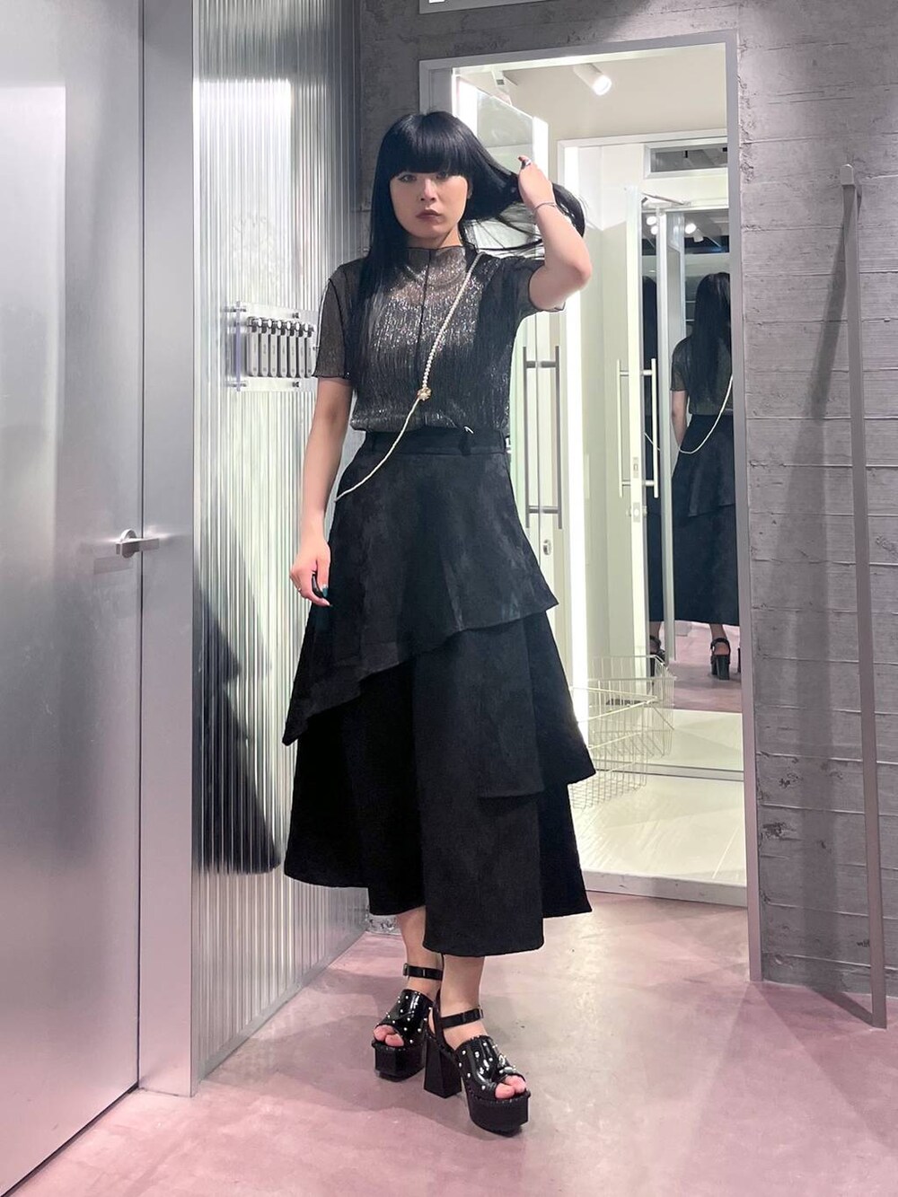 ブラック系のサンダル、ブラック系のスカート、ブラック系のTシャツ/カットソーを着用したレディースの春コーディネートの2枚目の写真