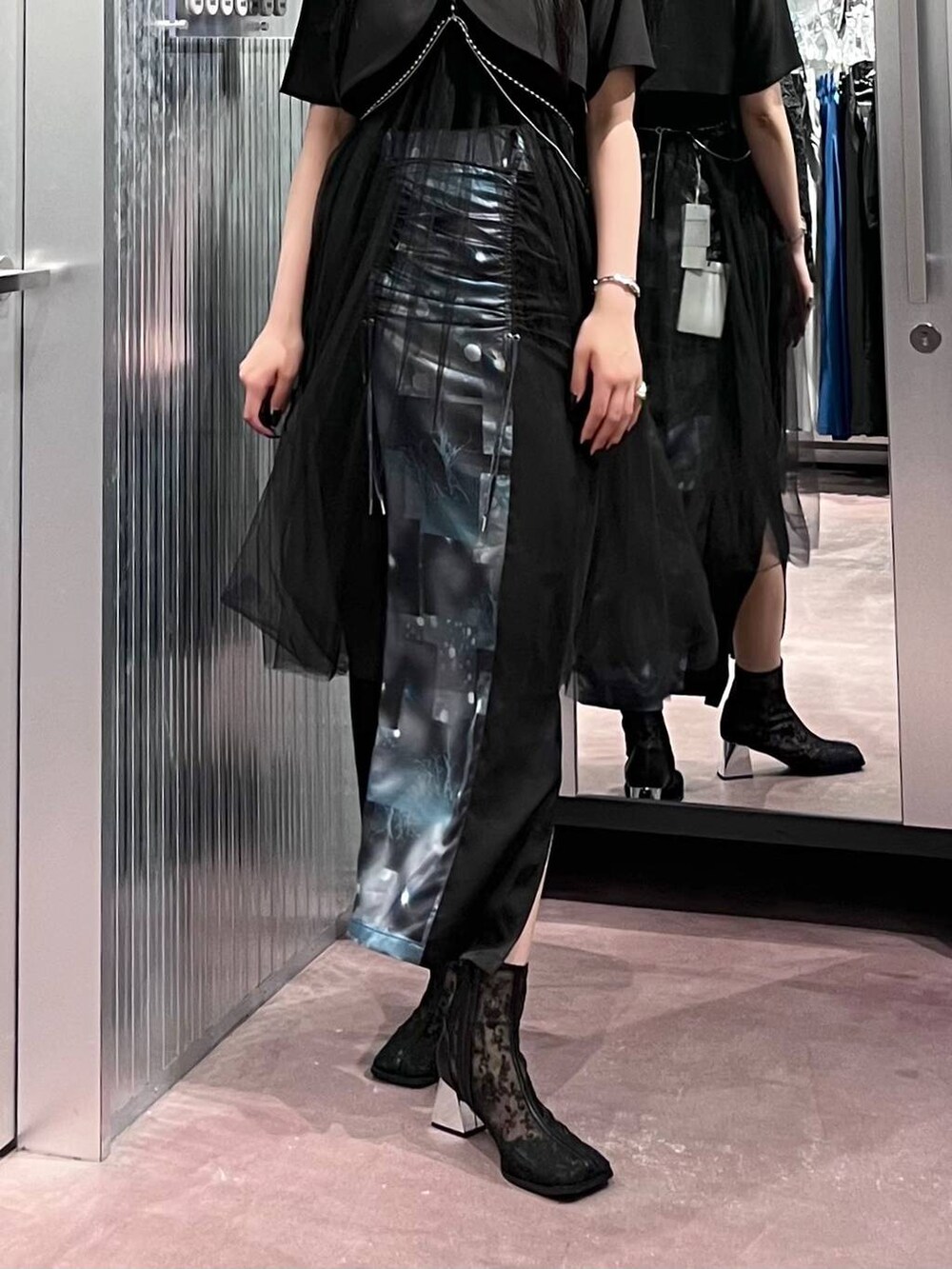 ブラック系のスカート、ブラック系のブーツ、ブラック系のブルゾンを着用したレディースの夏コーディネートの5枚目の写真