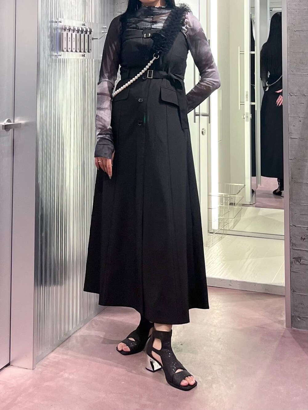 ブラック系のサンダル、ブラック系のジャンパースカート、ブラック系のTシャツ/カットソーを着用したレディースの夏コーディネートの8枚目の写真