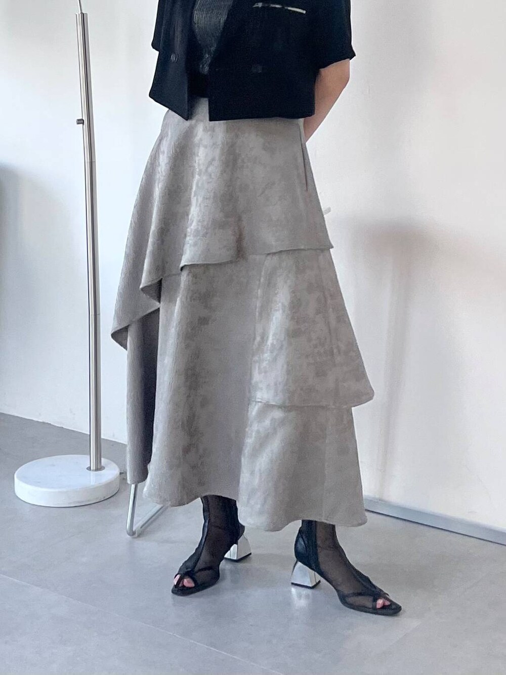 ブラック系のサンダル、グレー系のスカート、ブラック系のTシャツ/カットソーを着用したレディースの春コーディネートの4枚目の写真