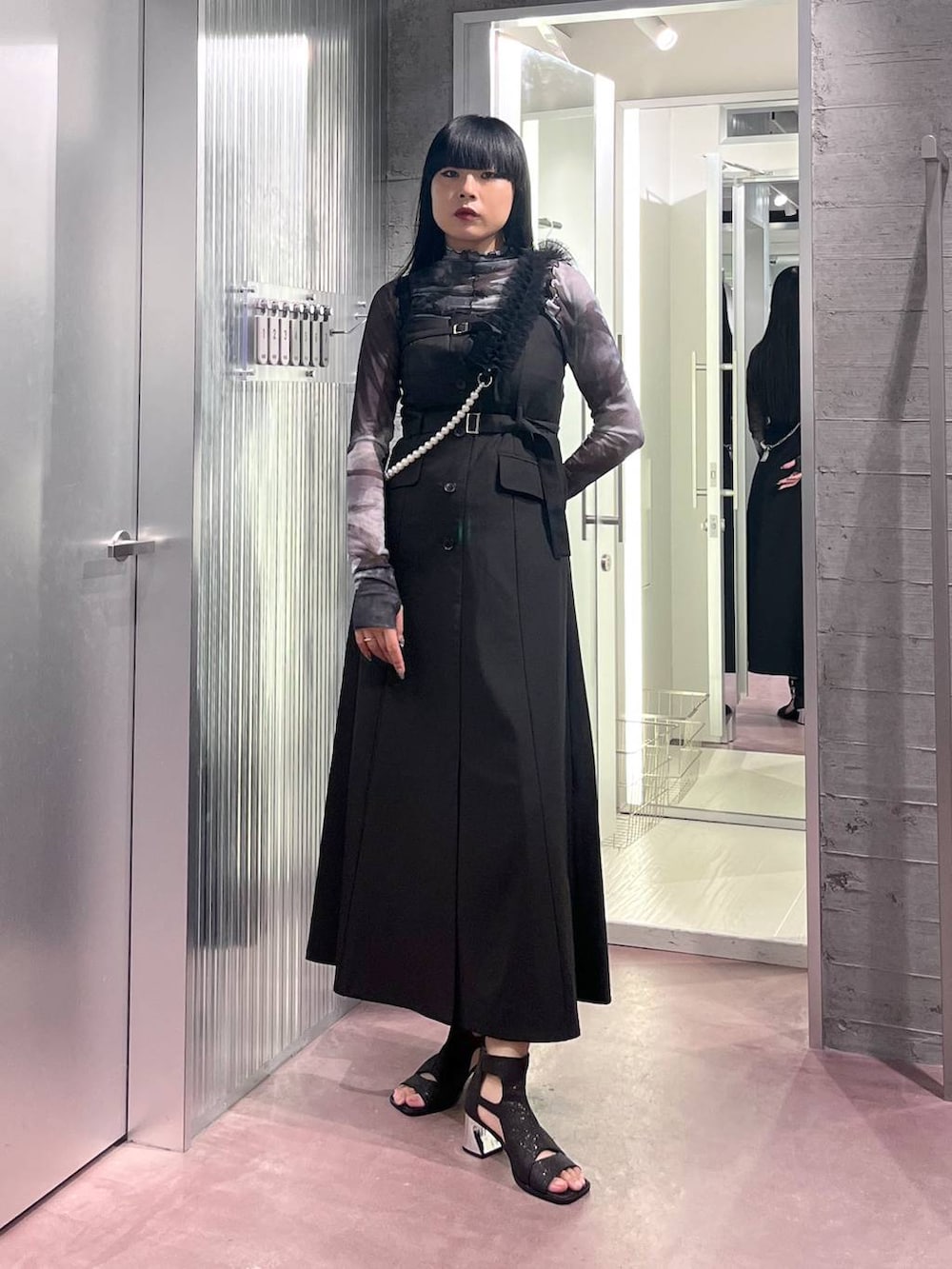 ブラック系のサンダル、ブラック系のジャンパースカート、ブラック系のTシャツ/カットソーを着用したレディースの夏コーディネートの4枚目の写真