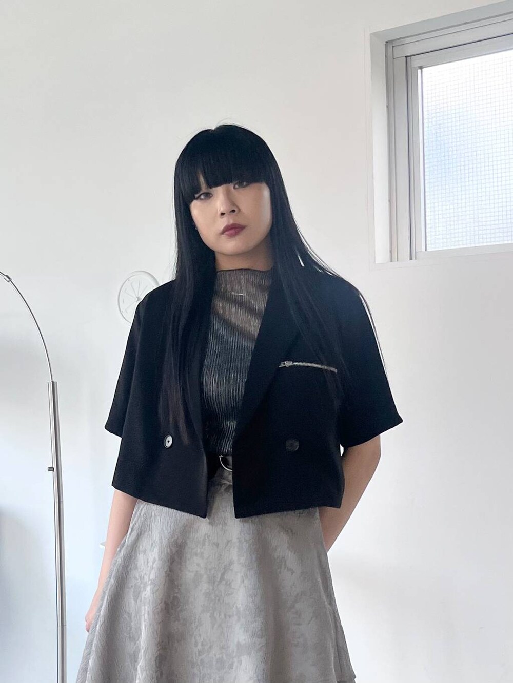 ブラック系のサンダル、グレー系のスカート、ブラック系のTシャツ/カットソーを着用したレディースの春コーディネートの3枚目の写真