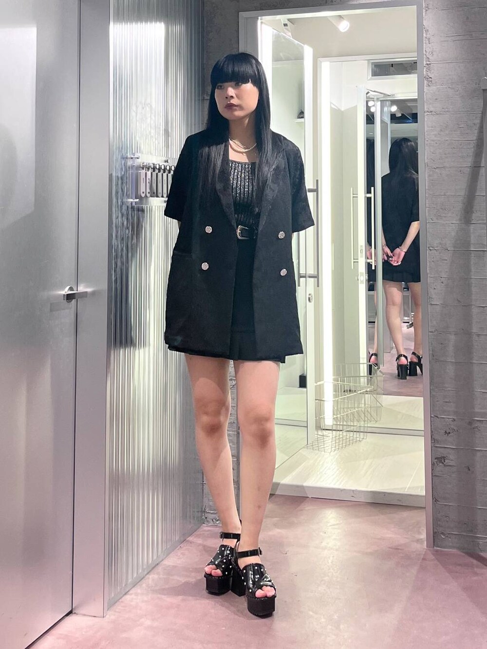 ブラック系のサンダル、ブラック系のタンクトップ、ブラック系のカーゴパンツを着用したレディースの春コーディネートの2枚目の写真