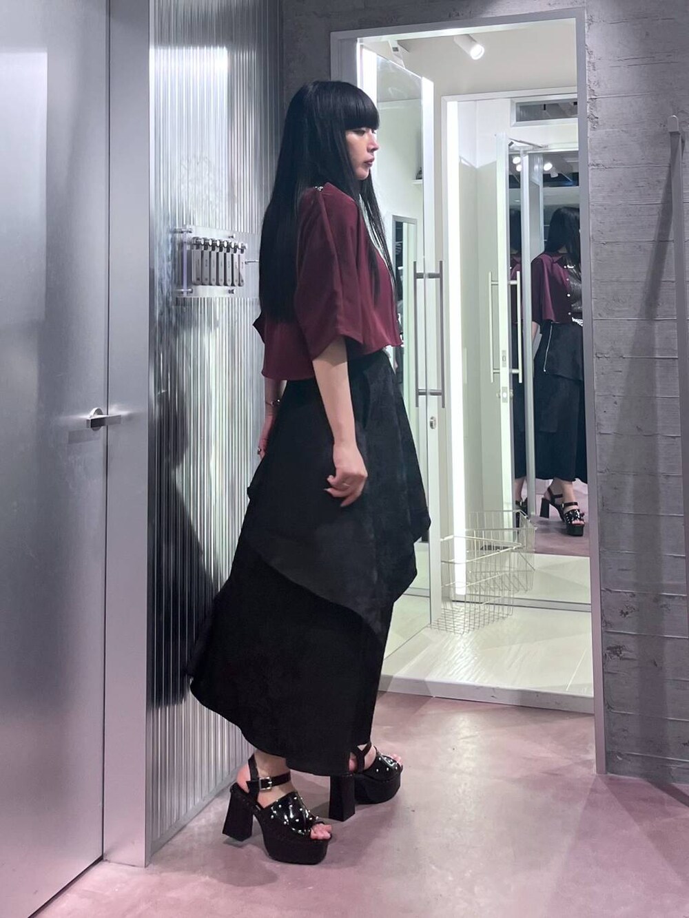 ブラック系のサンダル、レッド系のシャツ/ブラウス、ブラック系のスカートを着用したレディースの春コーディネートの6枚目の写真