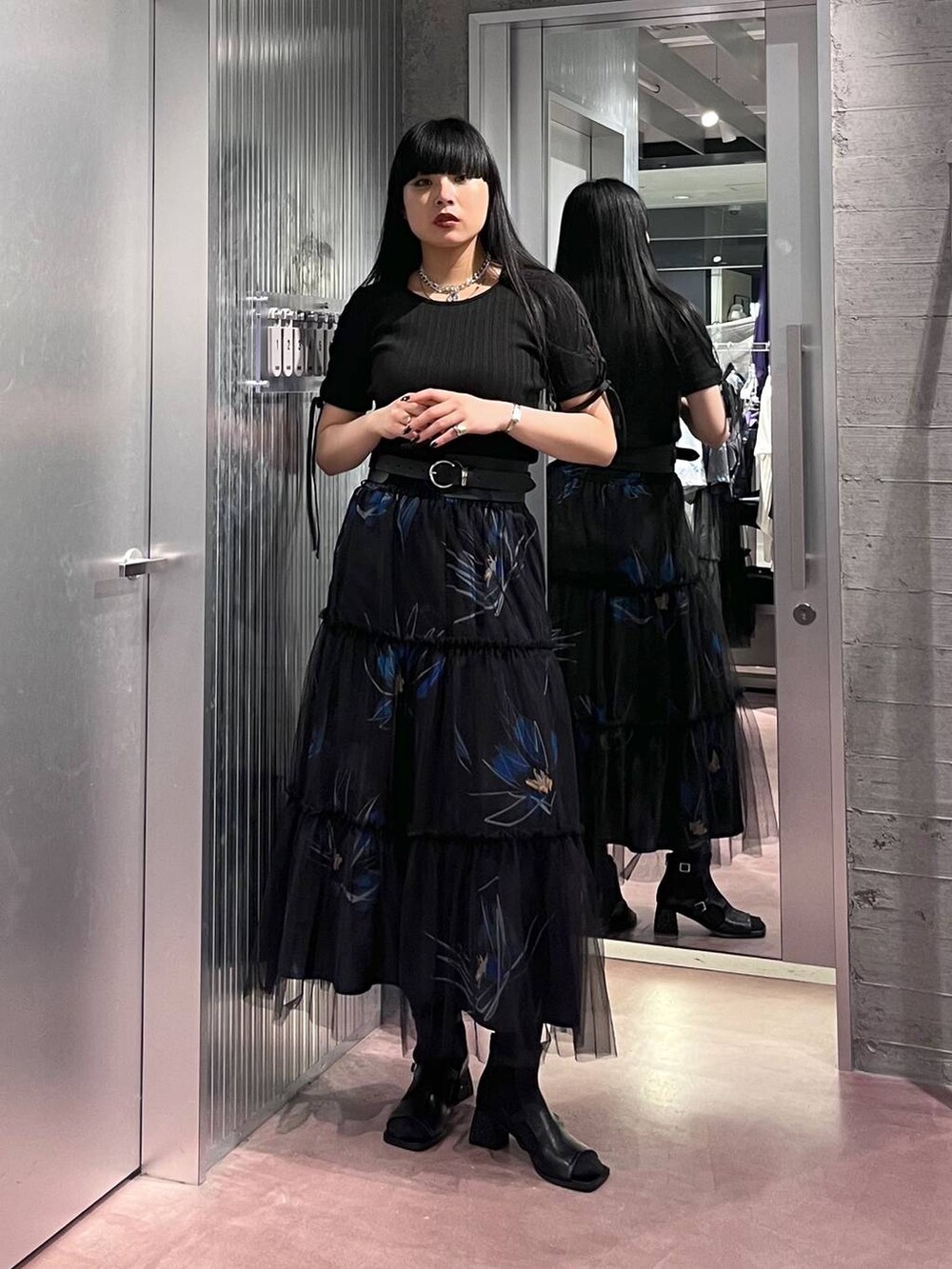 ブラック系のTシャツ/カットソー、ブラック系のスカート、ブラック系のサンダルを着用したレディースの春コーディネートの5枚目の写真