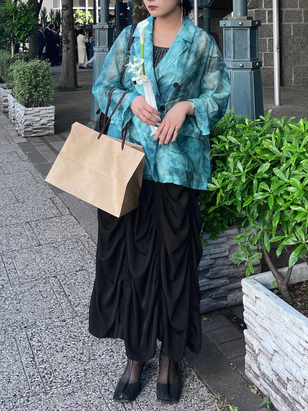 ブラック系のタンクトップ、ブラック系のスカート、グリーン系のテーラードジャケットを着用したレディースの春コーディネートの3枚目の写真