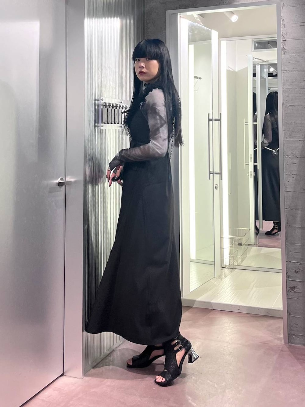 ブラック系のサンダル、ブラック系のジャンパースカート、ブラック系のTシャツ/カットソーを着用したレディースの夏コーディネートの2枚目の写真