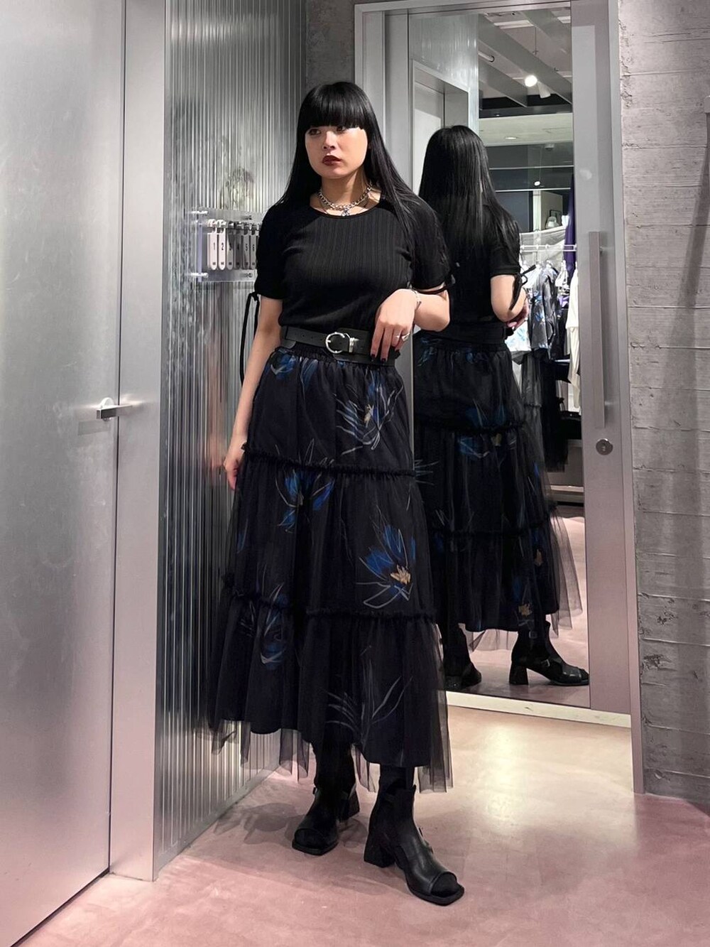 ブラック系のTシャツ/カットソー、ブラック系のスカート、ブラック系のサンダルを着用したレディースの春コーディネートの2枚目の写真