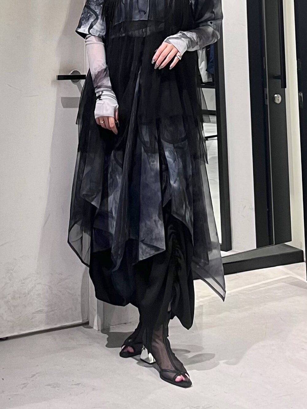 ブラック系のサンダル、ブラック系のスカート、ホワイト系のTシャツ/カットソーを着用したレディースの春コーディネートの6枚目の写真