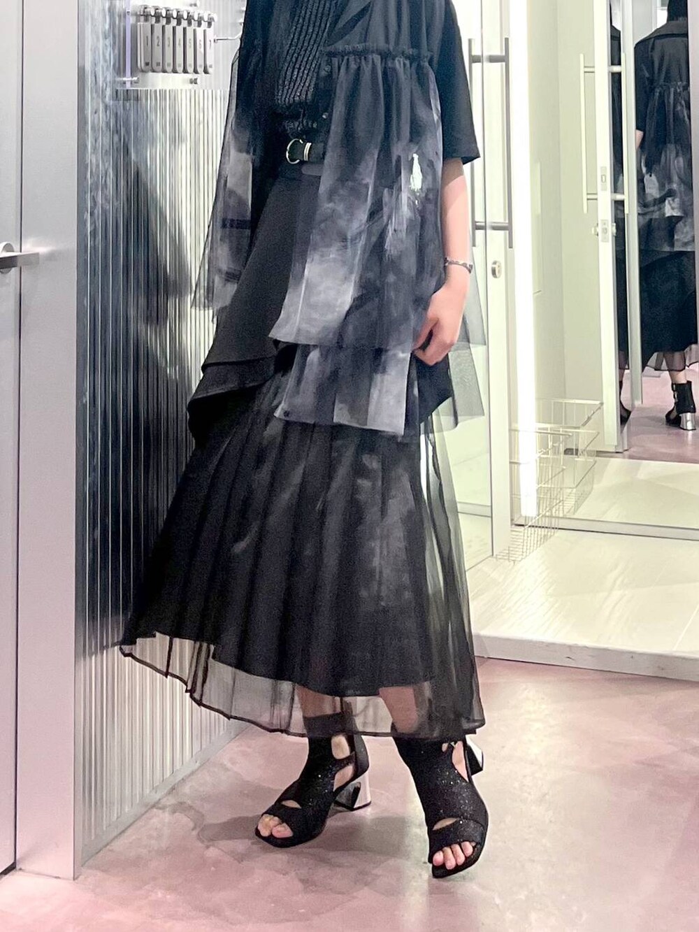 ブラック系のタンクトップ、ブラック系のスカート、ブラック系のサンダルを着用したレディースの夏コーディネートの4枚目の写真