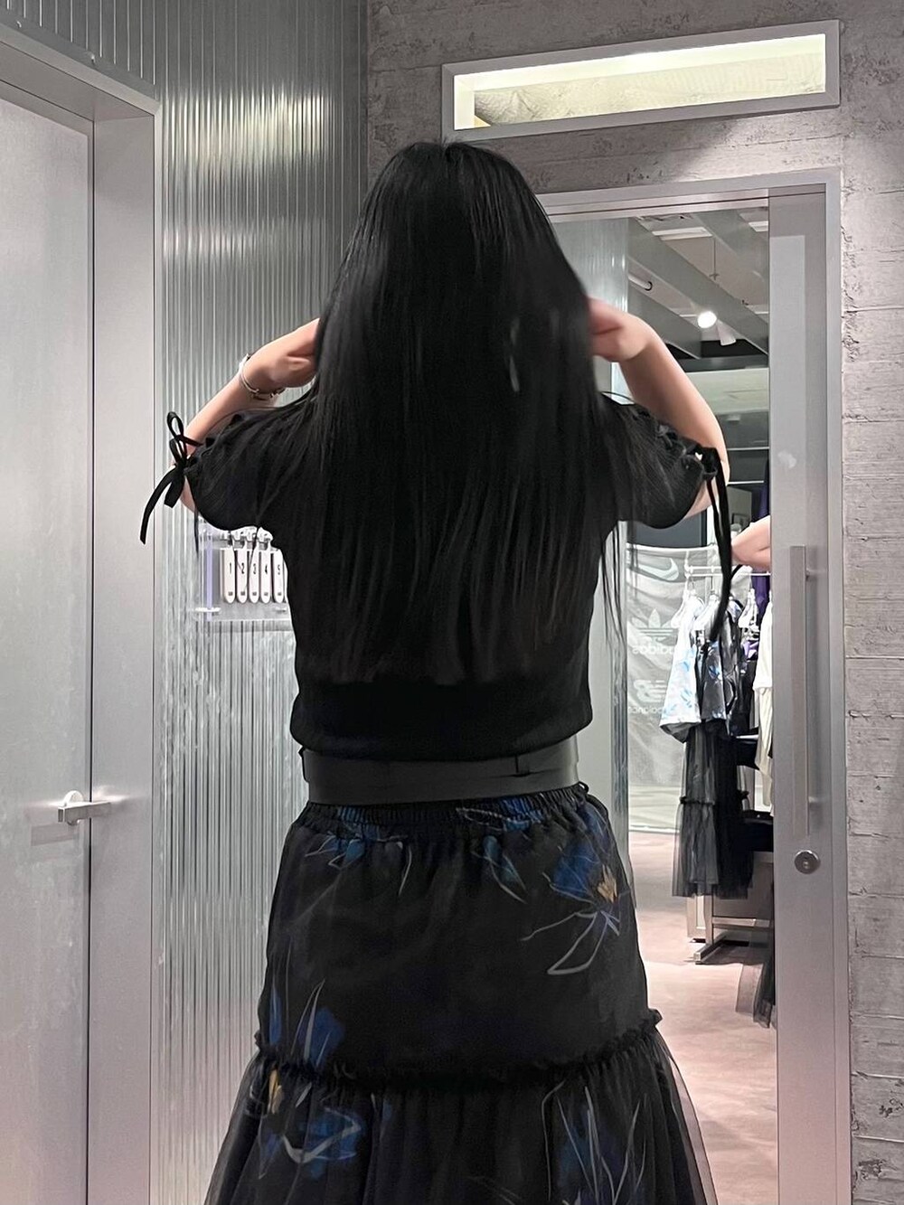 ブラック系のTシャツ/カットソー、ブラック系のスカート、ブラック系のサンダルを着用したレディースの春コーディネートの9枚目の写真