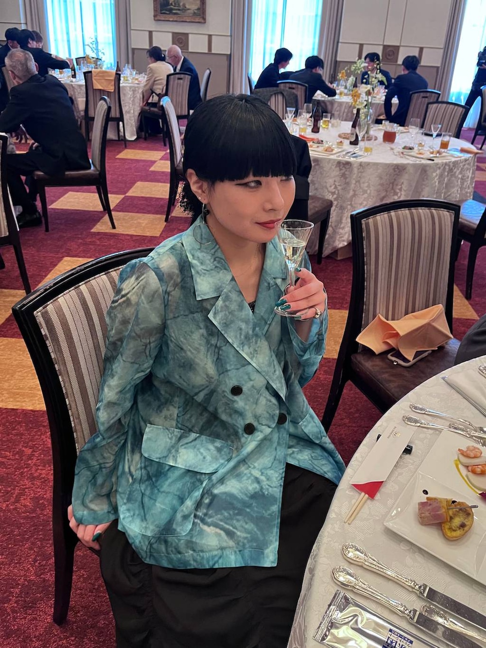 ブラック系のタンクトップ、ブラック系のスカート、グリーン系のテーラードジャケットを着用したレディースの春コーディネートの4枚目の写真