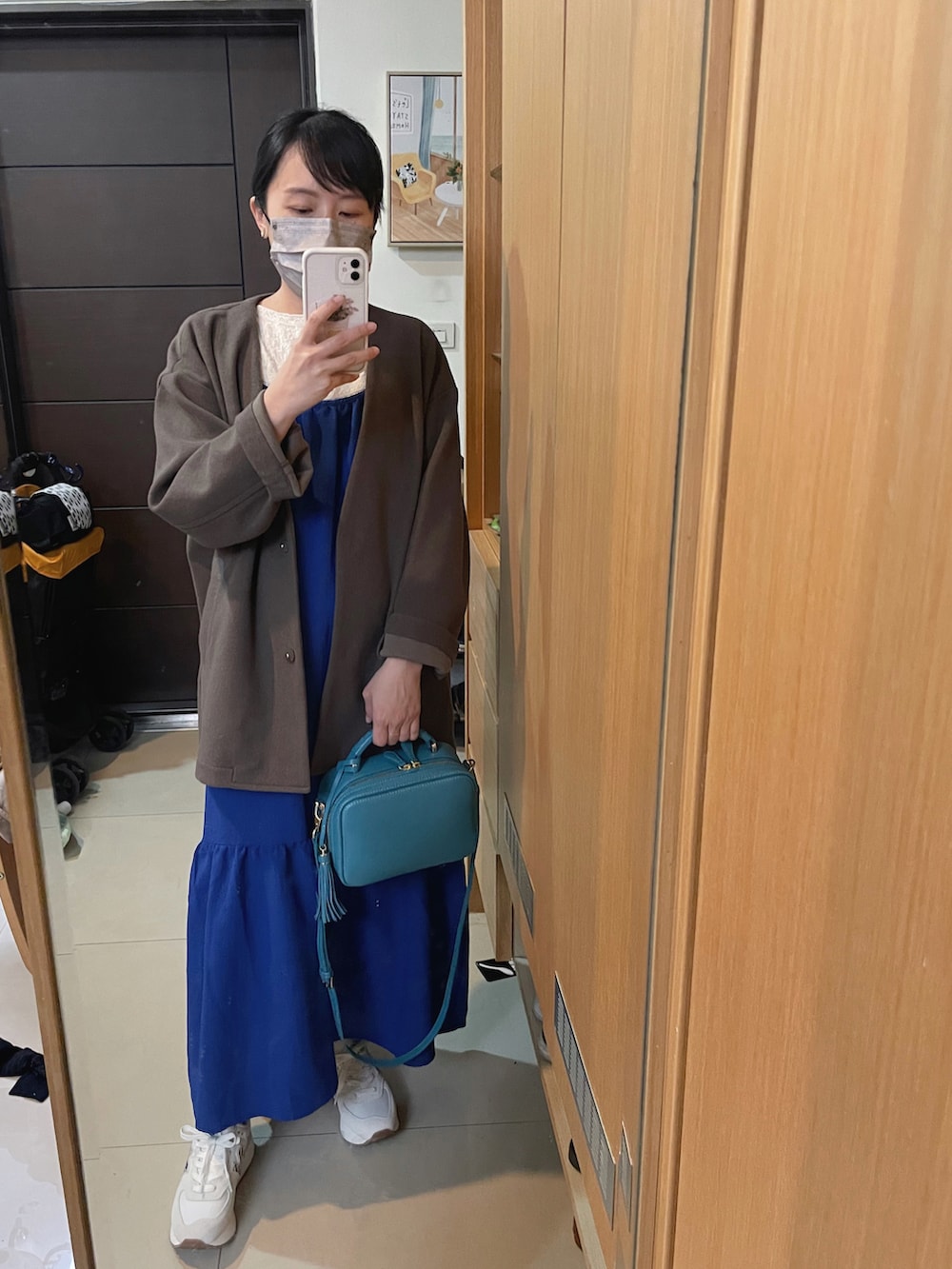 ブルー系のバッグ、ホワイト系のスニーカーを着用したレディースの春コーディネートの2枚目の写真