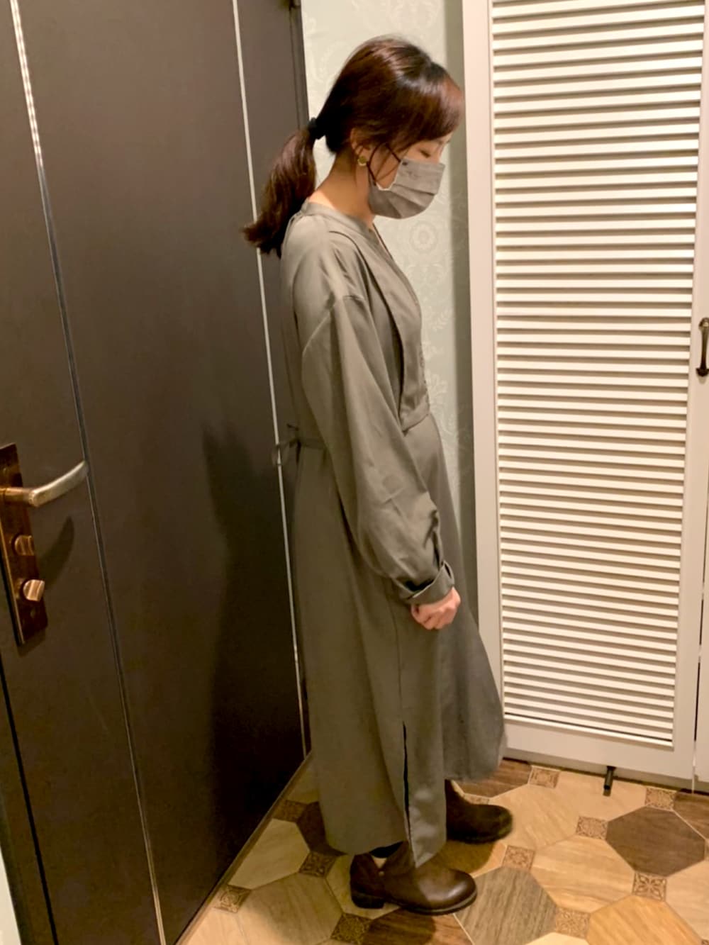 グレー系のハンドバッグ、ブラウン系のブーツを着用したレディースの春コーディネートの2枚目の写真