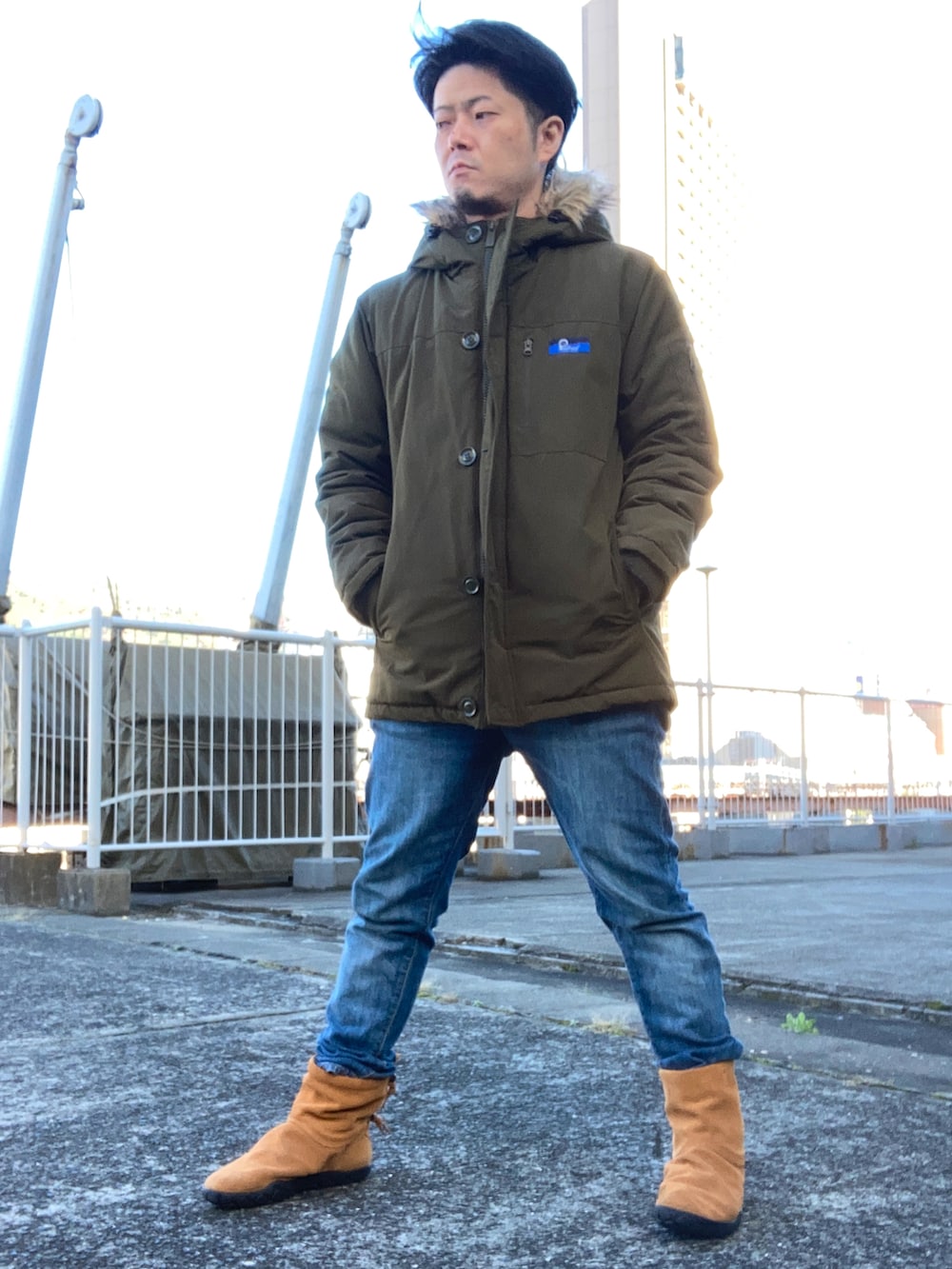 ホワイト系のニット/セーター、グリーン系のミリタリージャケット、ブルー系のデニムパンツを着用したメンズの秋コーディネートの2枚目の写真