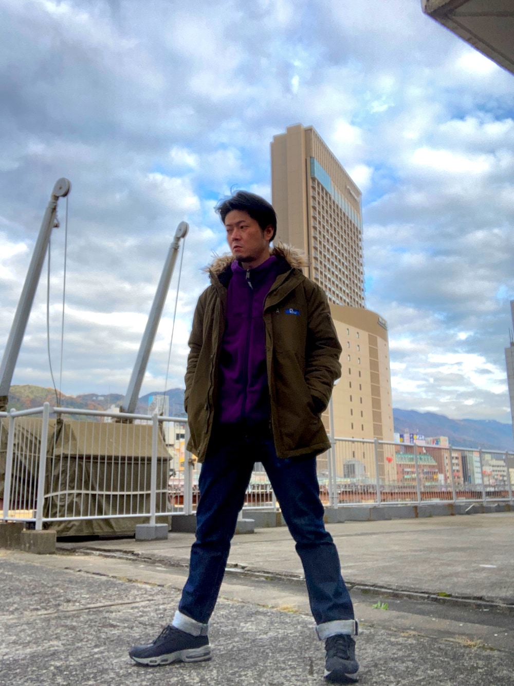 パープル系のその他アウター、グリーン系のミリタリージャケット、ブルー系のデニムパンツを着用したメンズの冬コーディネートの3枚目の写真