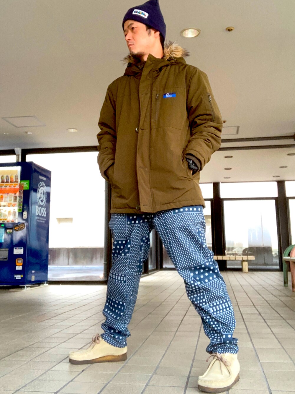 グリーン系のミリタリージャケット、レッド系のスウェット、ブルー系のその他パンツを着用したメンズの秋コーディネートの2枚目の写真